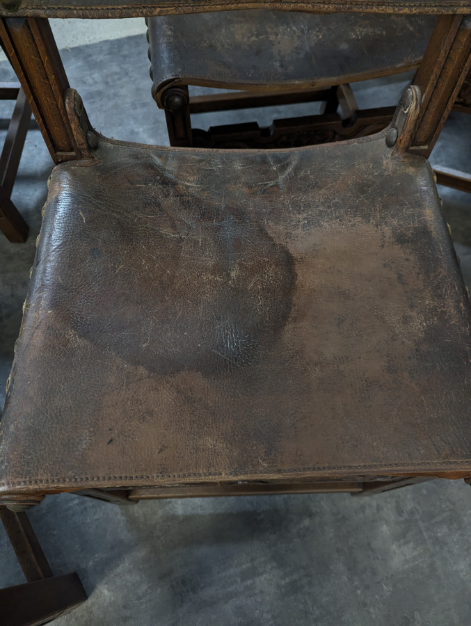 Série de 8 chaises de style gothique en chêne et cuir clouté