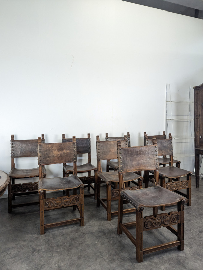 Série de 8 chaises de style gothique en chêne et cuir clouté