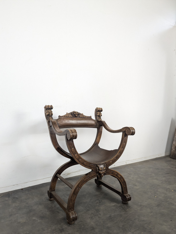 Fauteuil curule Dagobert en noyer sculpté de têtes de lion