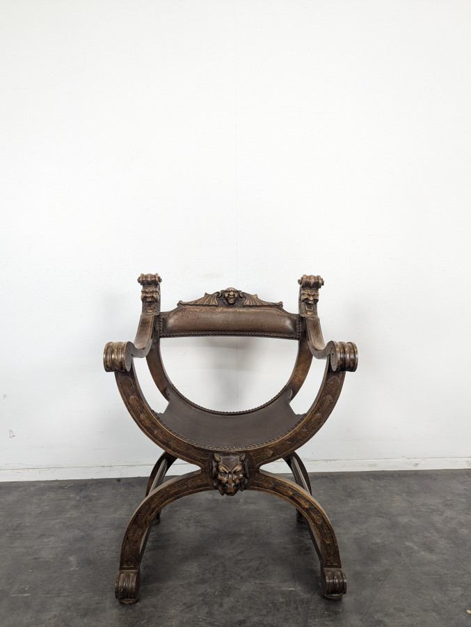 Fauteuil curule Dagobert en noyer sculpté de têtes de lion