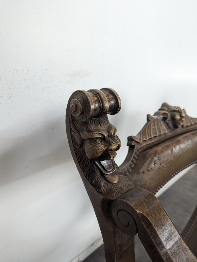 Fauteuil curule Dagobert en noyer sculpté de têtes de lion