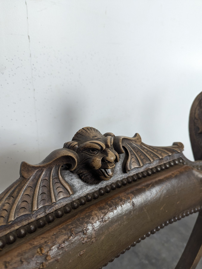 Fauteuil curule Dagobert en noyer sculpté de têtes de lion