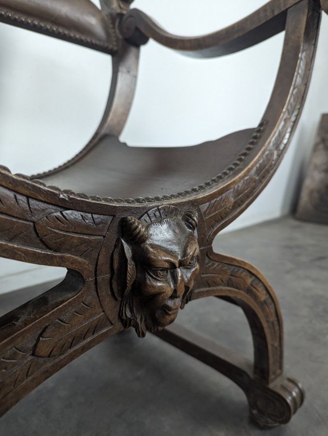Fauteuil curule Dagobert en noyer sculpté de têtes de lion