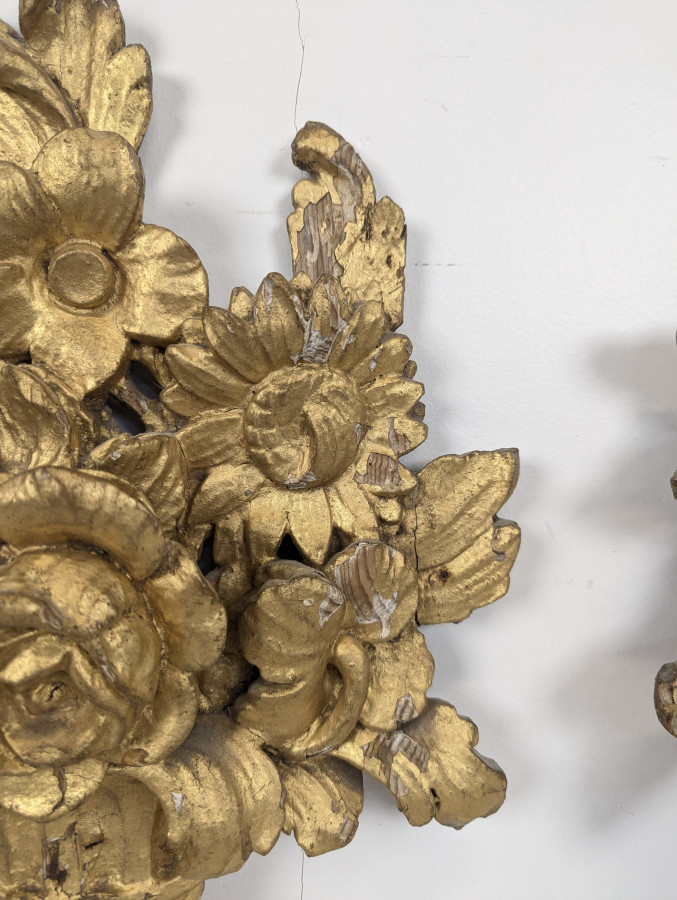 Paire d'ornements en bois sculpté et doré à bouquets fleuris