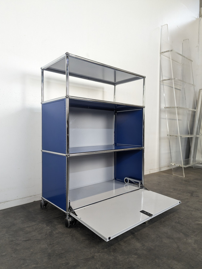 Meuble USM Haller bleu gentiane et blanc à porte abattante sur roulettes