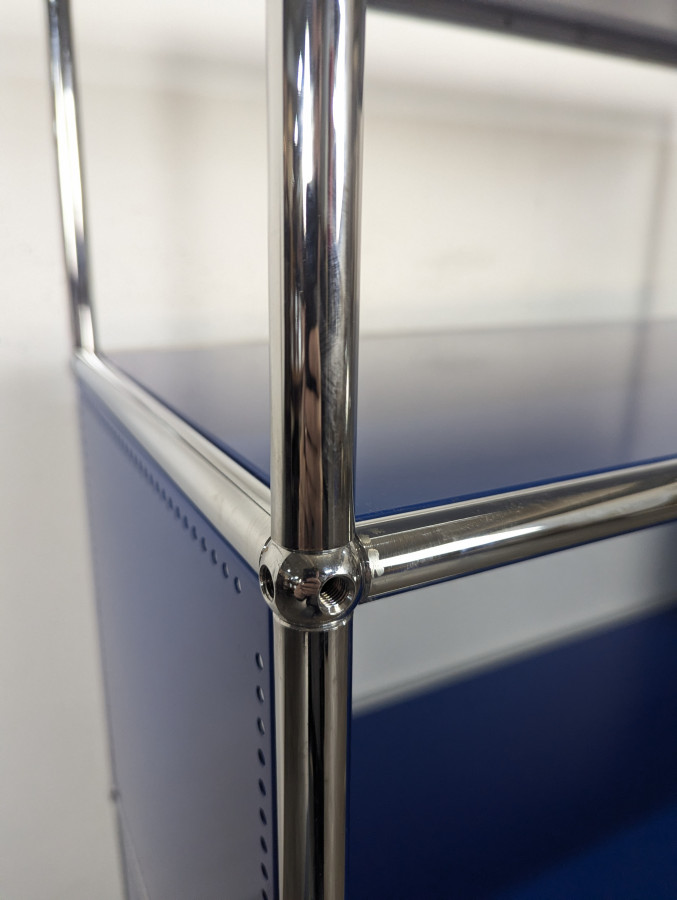 Meuble USM Haller bleu gentiane et blanc à porte abattante sur roulettes