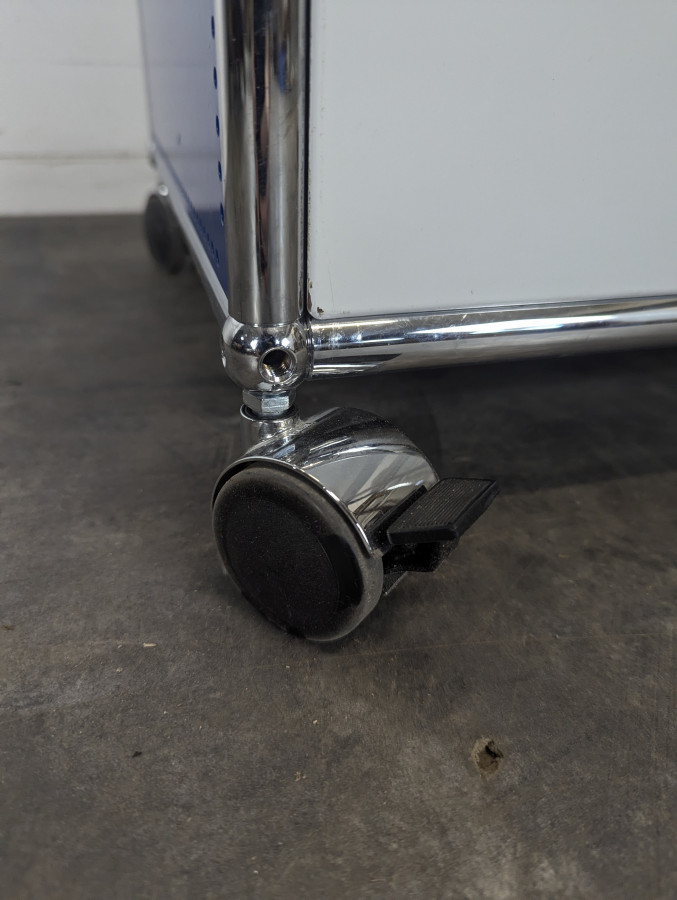 Meuble USM Haller bleu gentiane et blanc à porte abattante sur roulettes