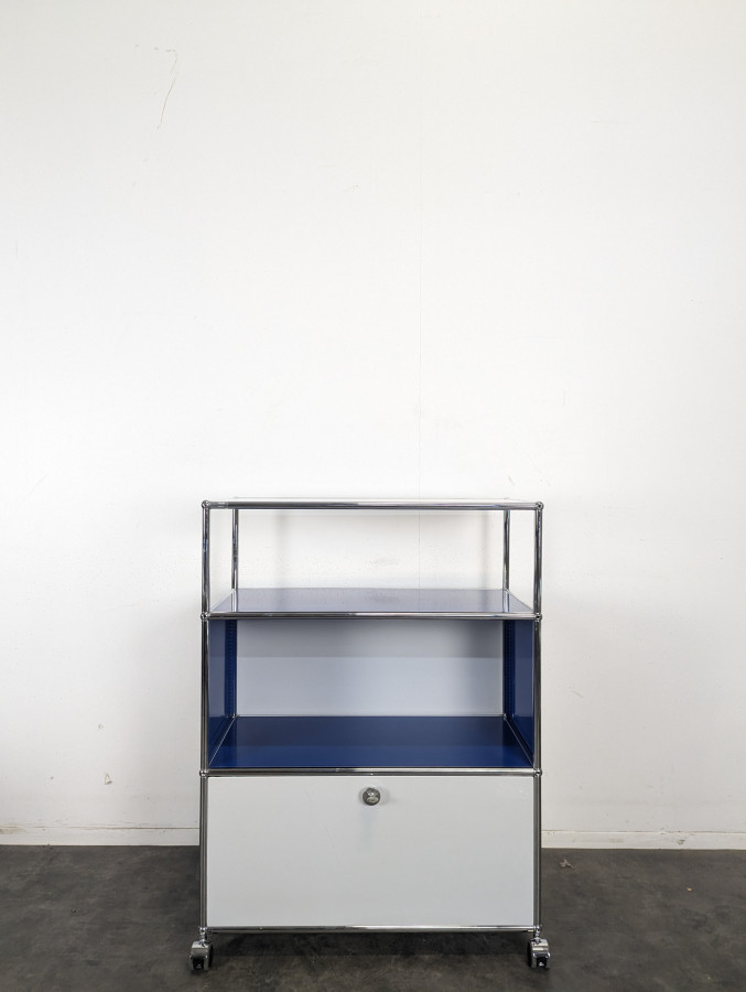 Meuble USM Haller bleu gentiane et blanc à porte abattante sur roulettes