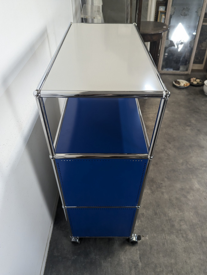 Meuble USM Haller bleu gentiane et blanc à porte abattante sur roulettes