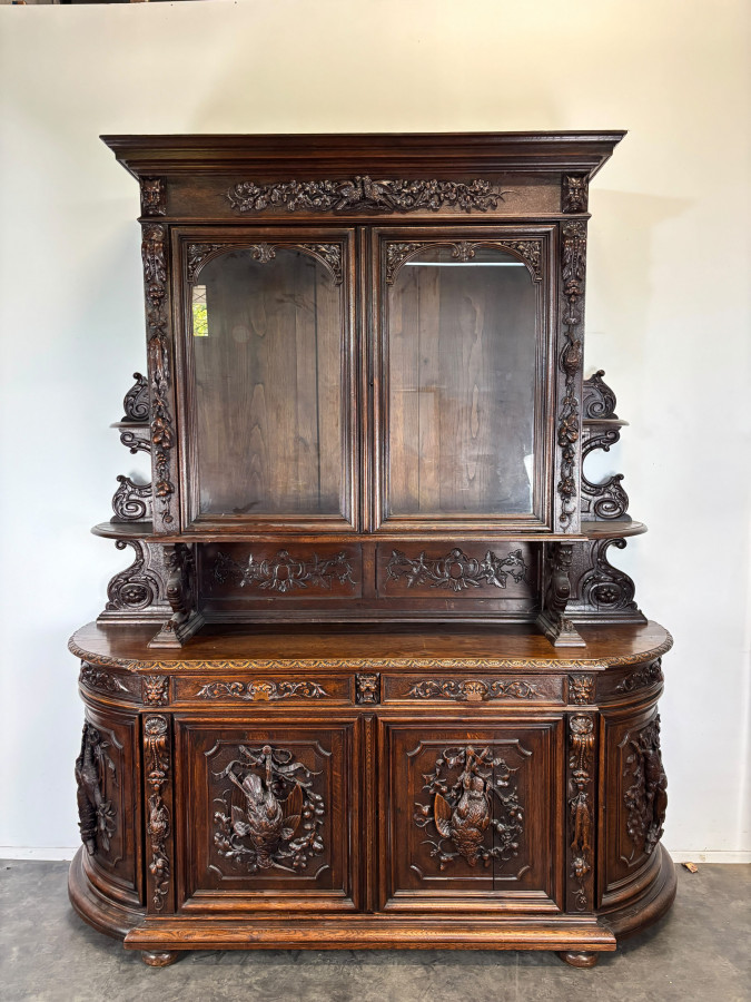 Buffet deux corps de chasse de style Henri II en chêne sculpté vitré