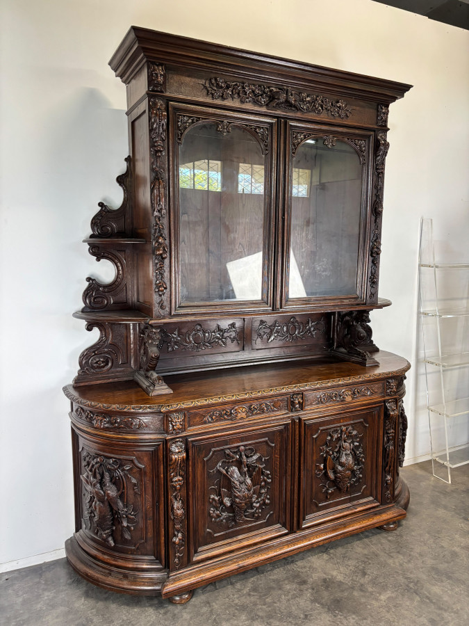 Buffet deux corps de chasse de style Henri II en chêne sculpté vitré