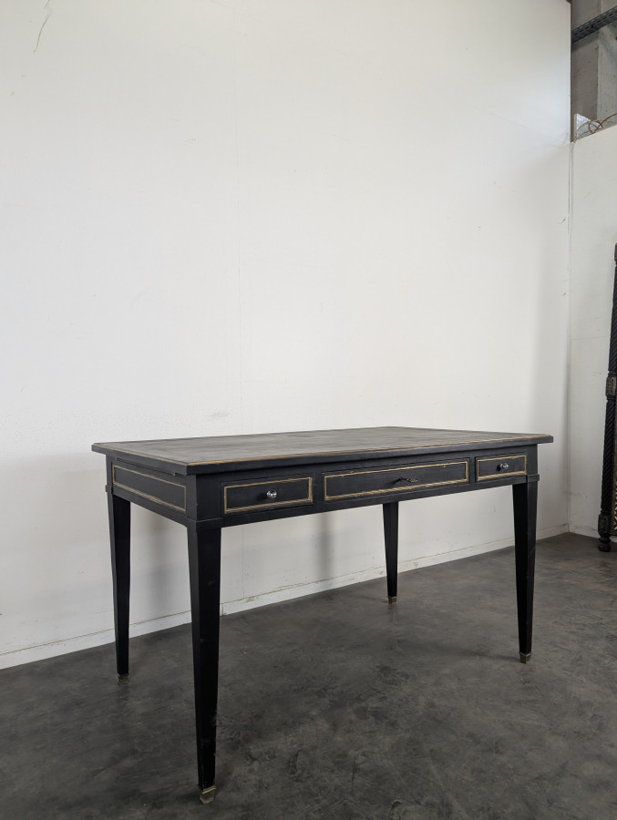 Grand bureau plat de style Louis XVI laqué noir et rechampi or