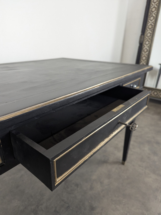 Grand bureau plat de style Louis XVI laqué noir et rechampi or