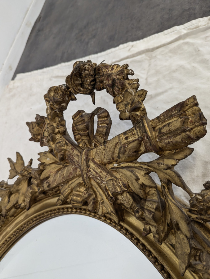 Miroir ovale de style Louis XVI fin XIXe en bois et stuc doré