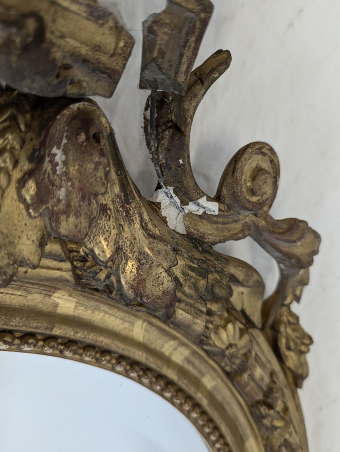Miroir ovale de style Louis XVI fin XIXe en bois et stuc doré