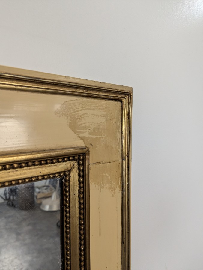Miroir de style Louis XVI en bois laqué crème et doré à rang de perles