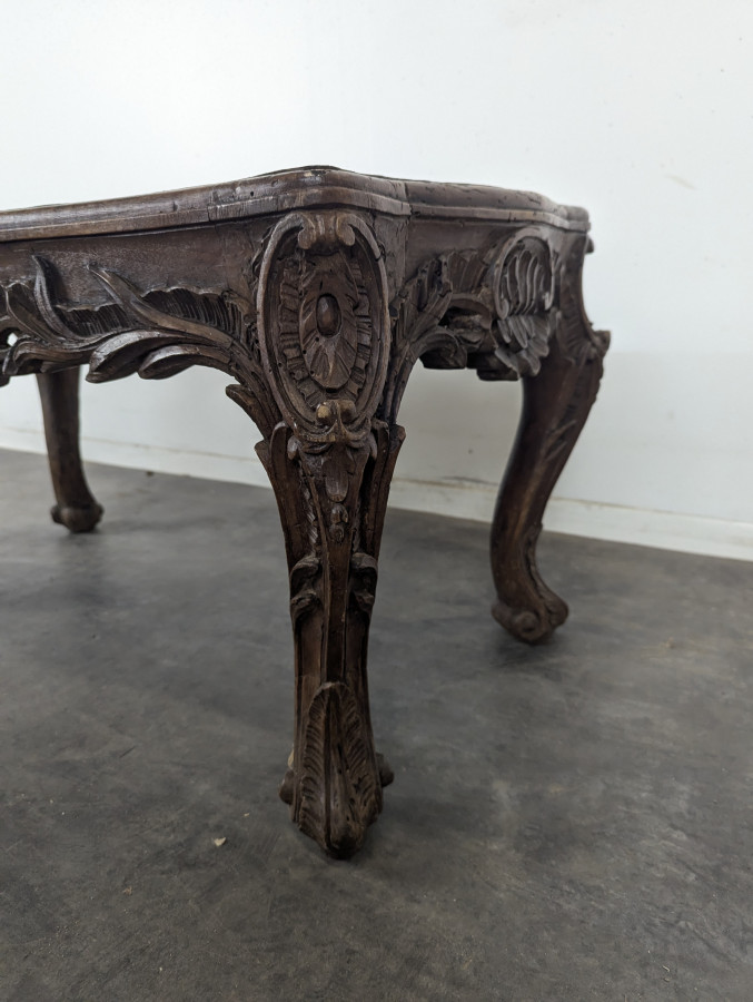 Table basse Louis XV en noyer sculpté à plateau de cuir doré